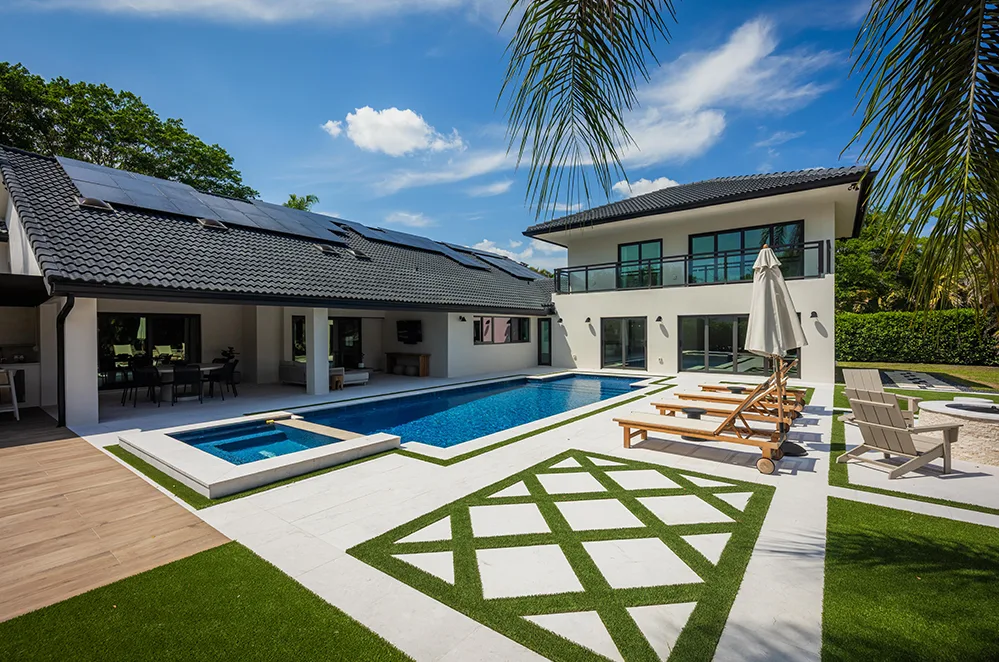 Custom pool with turf and paver deck and covered patio