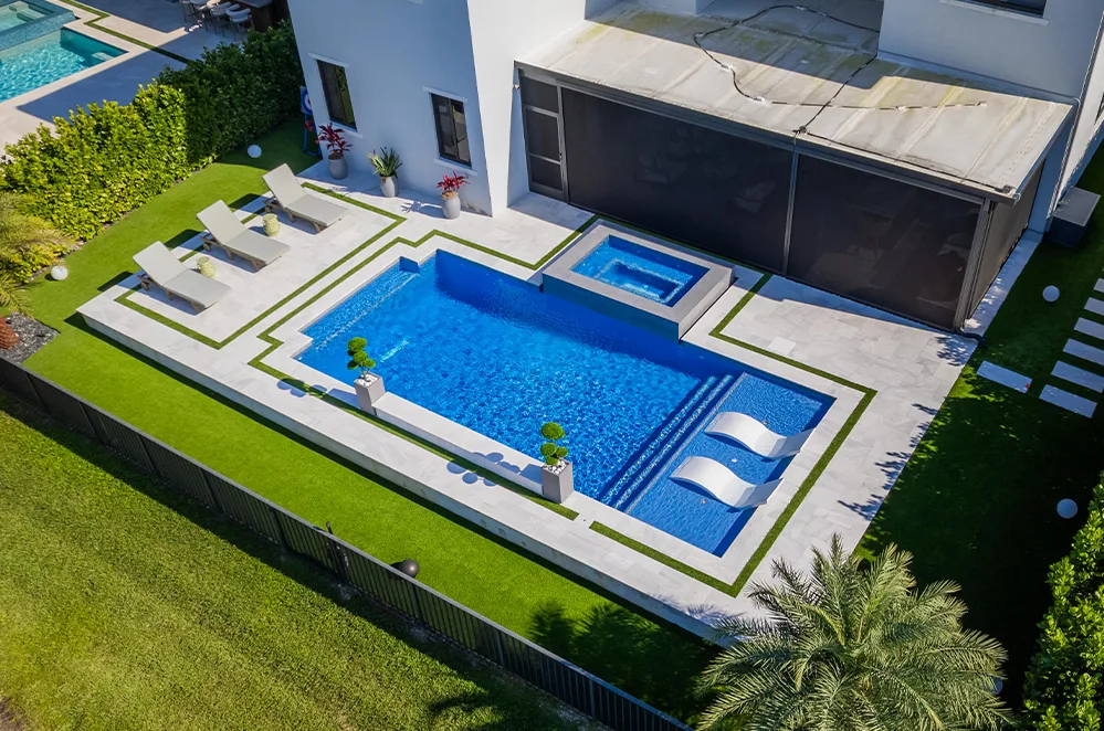 Aerial view of a modern pool with sun shelf and turf