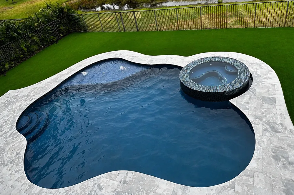 Freeform pool with attached spa and turf